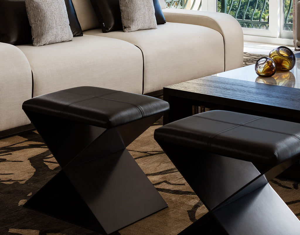 Santorini Stool with two black leather ottomans featuring X-shaped bases for stylish seating