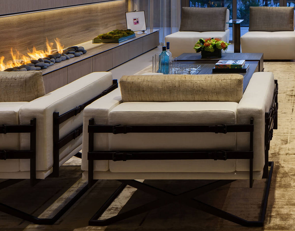 Contemporary living room featuring Rome Chair, long fireplace, two armchairs, and coffee table