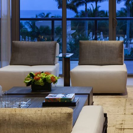 Modern living room furniture with Lucca Chair, light-colored armless chairs, and dark wood coffee table