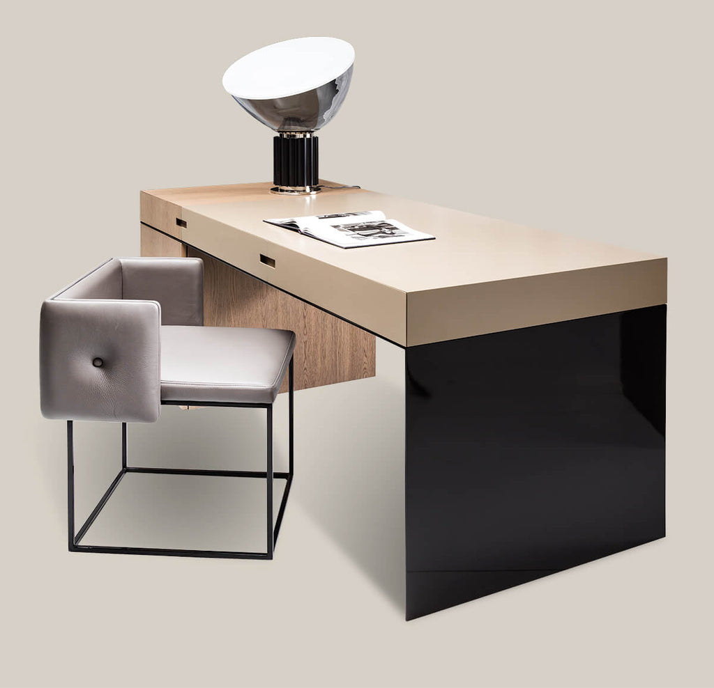 Brussels Desk featuring a modern beige surface, black side panel, and gray upholstered chair