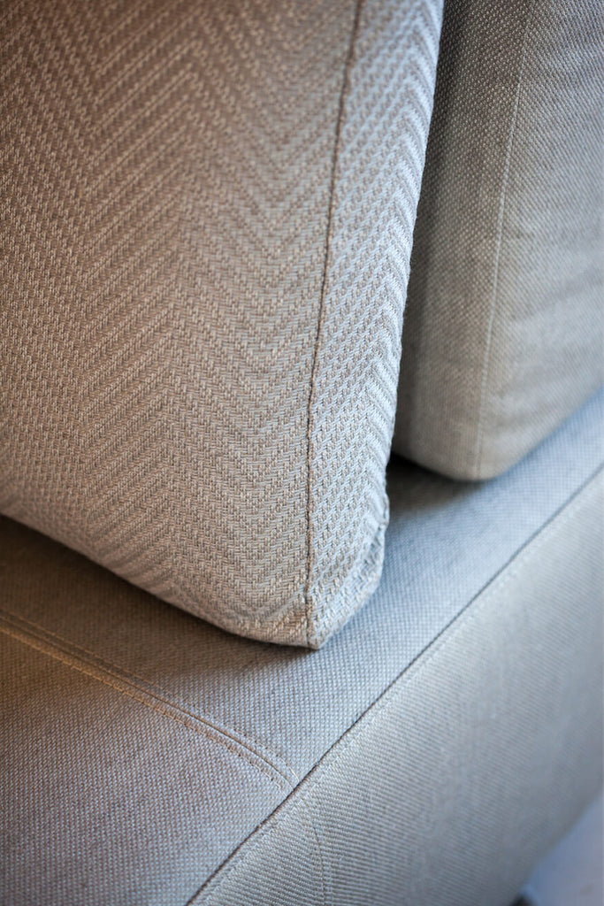 Light-colored fabric cushion with subtle herringbone pattern on Lucca Chair for stylish comfort