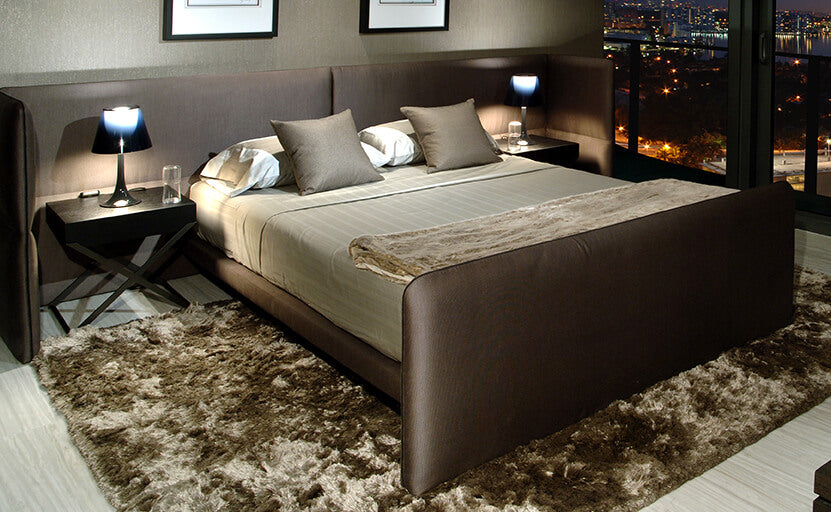 Modern bedroom with Venice Bed featuring a brown upholstered frame and decorative pillows