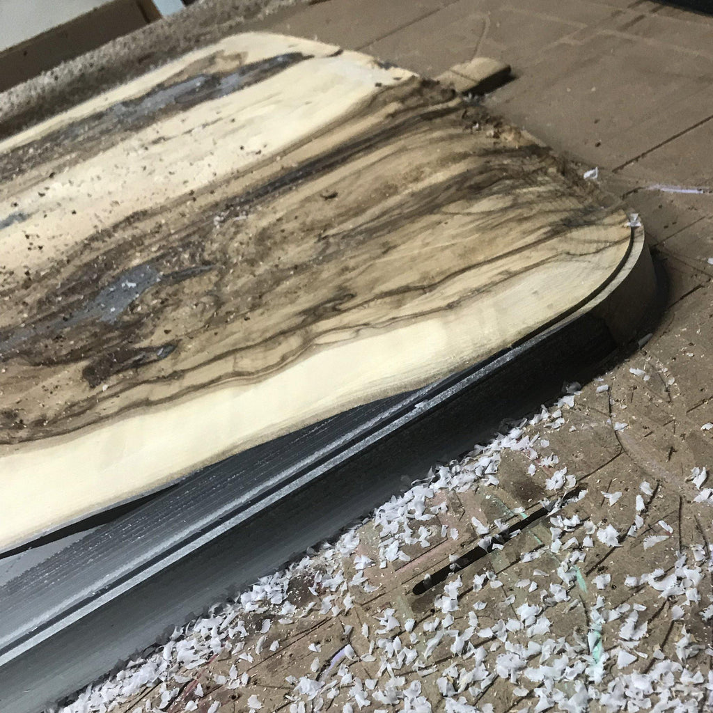 Amathus Ash Wood Dining Table with a wooden cutting board showcasing dark grain patterns