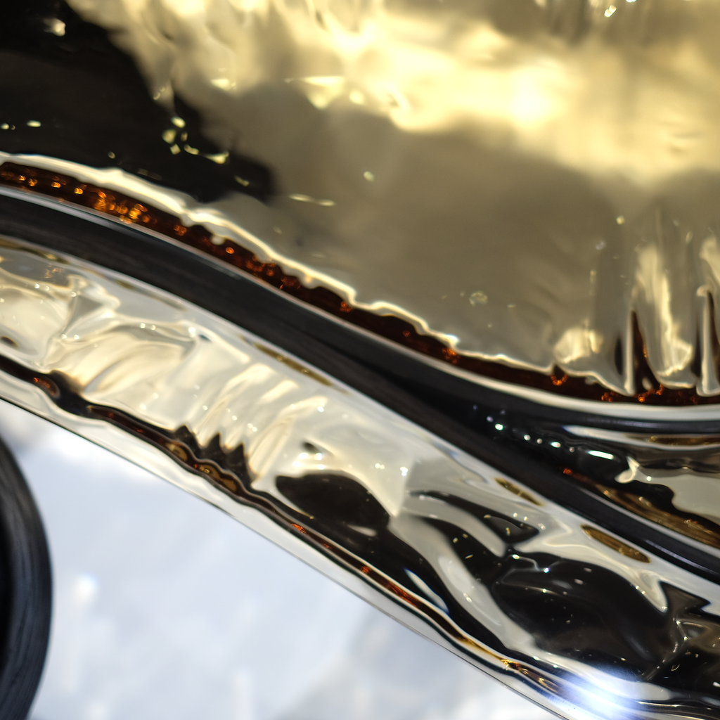 Close-up of Black Ivy Coffee Table chrome trim and dark-tinted window reflection