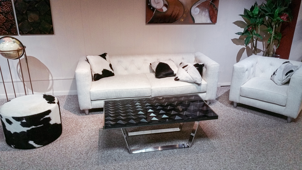 White leather sofa with black and white cowhide pillows next to Phebus Diamond Black Coffee Table