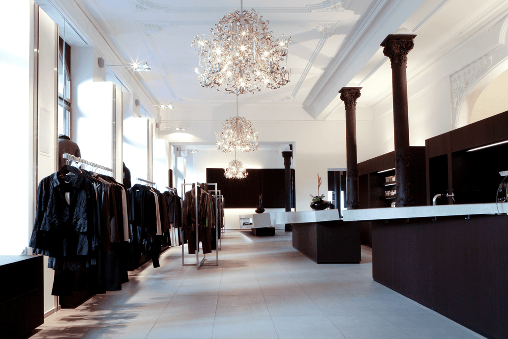Elegant flower power chandelier in a stylish clothing store interior with dark fixtures