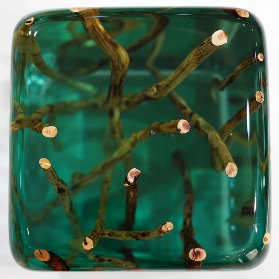 Green branches cube end table with clear green resin encasing natural cut tree branches