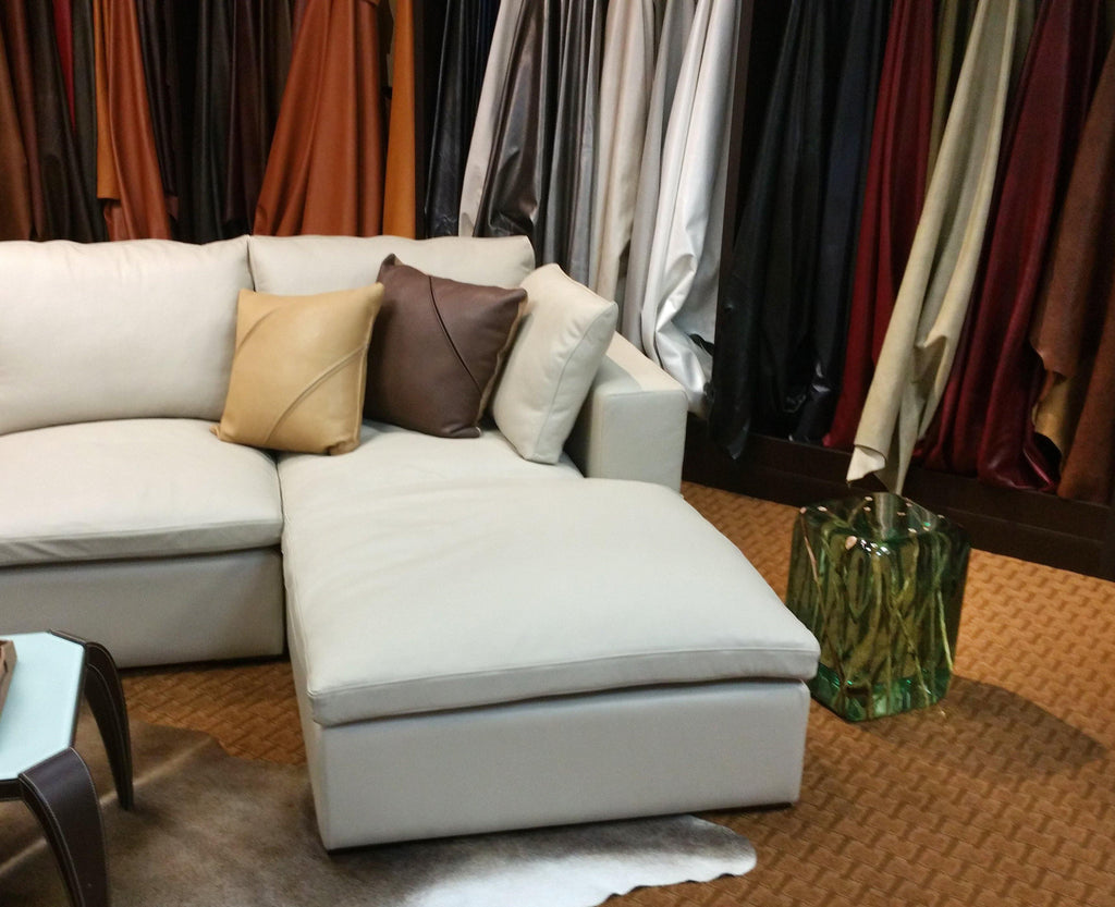 Light-colored sectional sofa with decorative throw pillows next to Green Branches Cube End Table