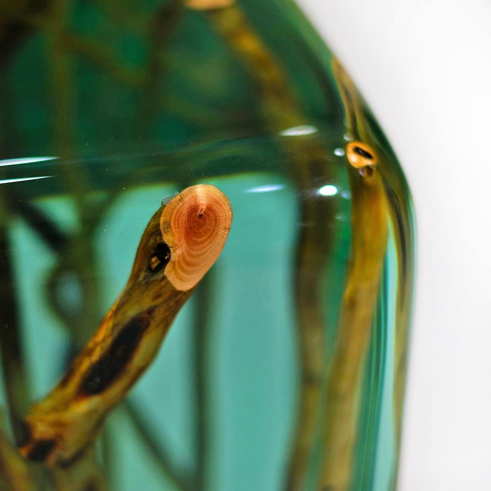 Green branches end table with wood encased in clear resin for decorative appeal