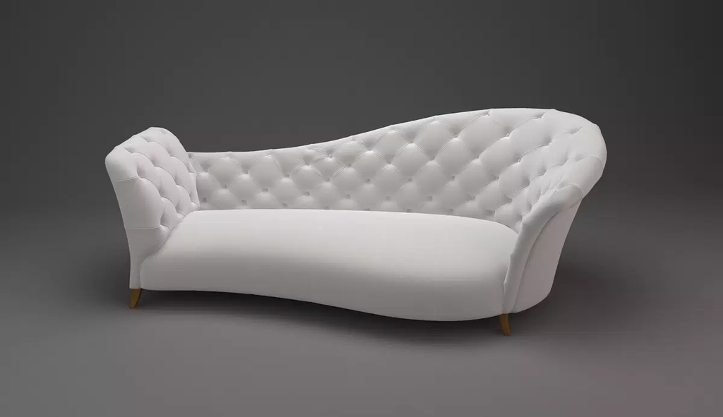 White tufted chaise lounge sofa with wooden legs in Harry Hines Lounge setting