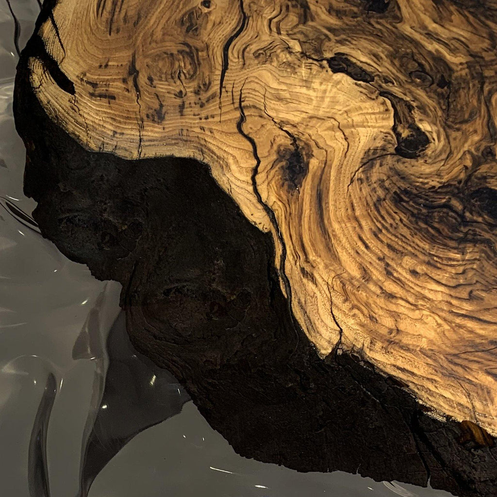 Arion Olive Wood Dining Table with live-edge slab, prominent grain, and dark epoxy accents