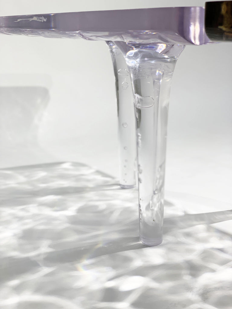 Clear acrylic table leg casting ripple shadow on Tyro Olive Wood Wavy Coffee Table