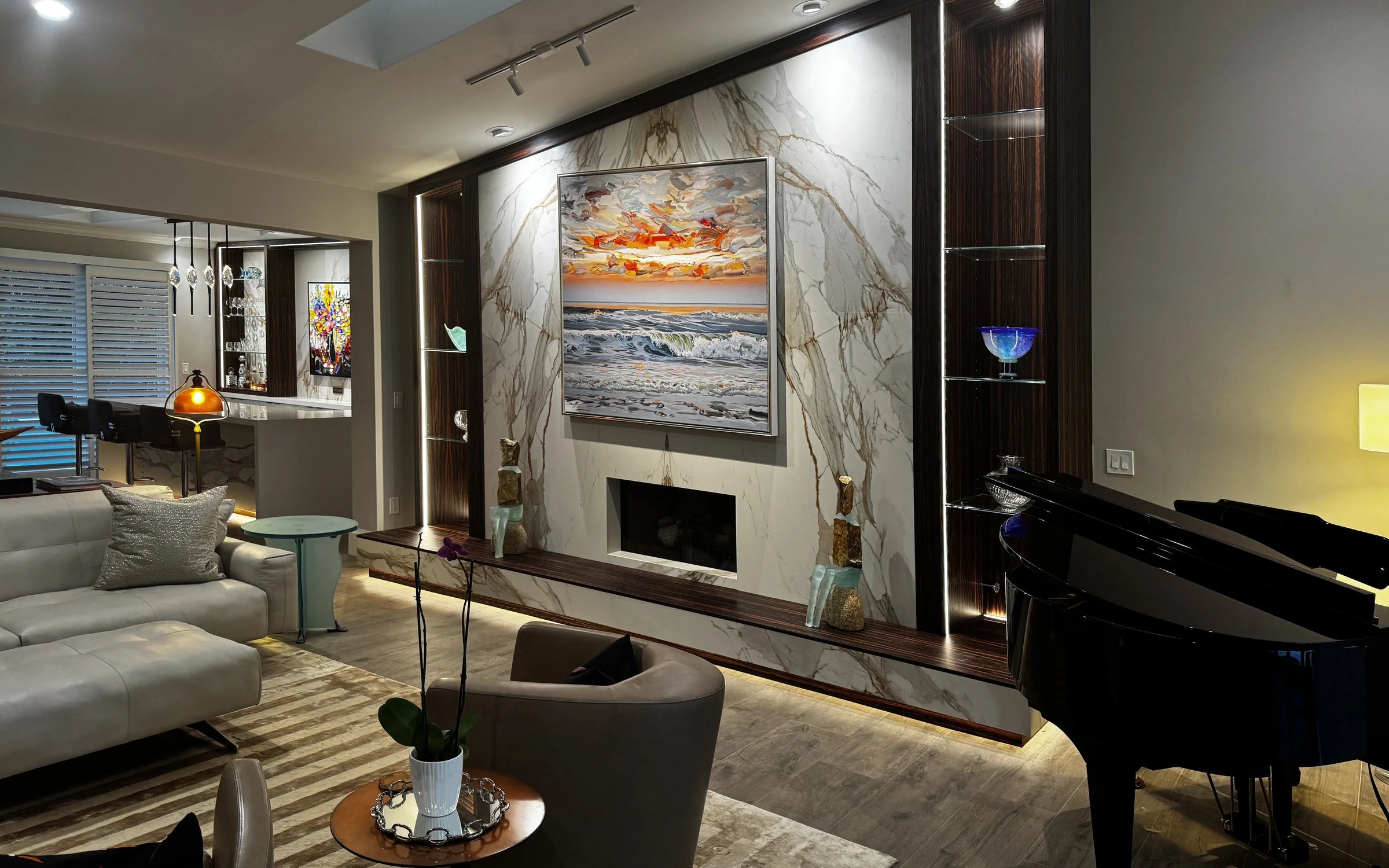 Residential living room featuring a porcelain fireplace wall, illuminated custom-veneered display niches, and bespoke architectural detailing.